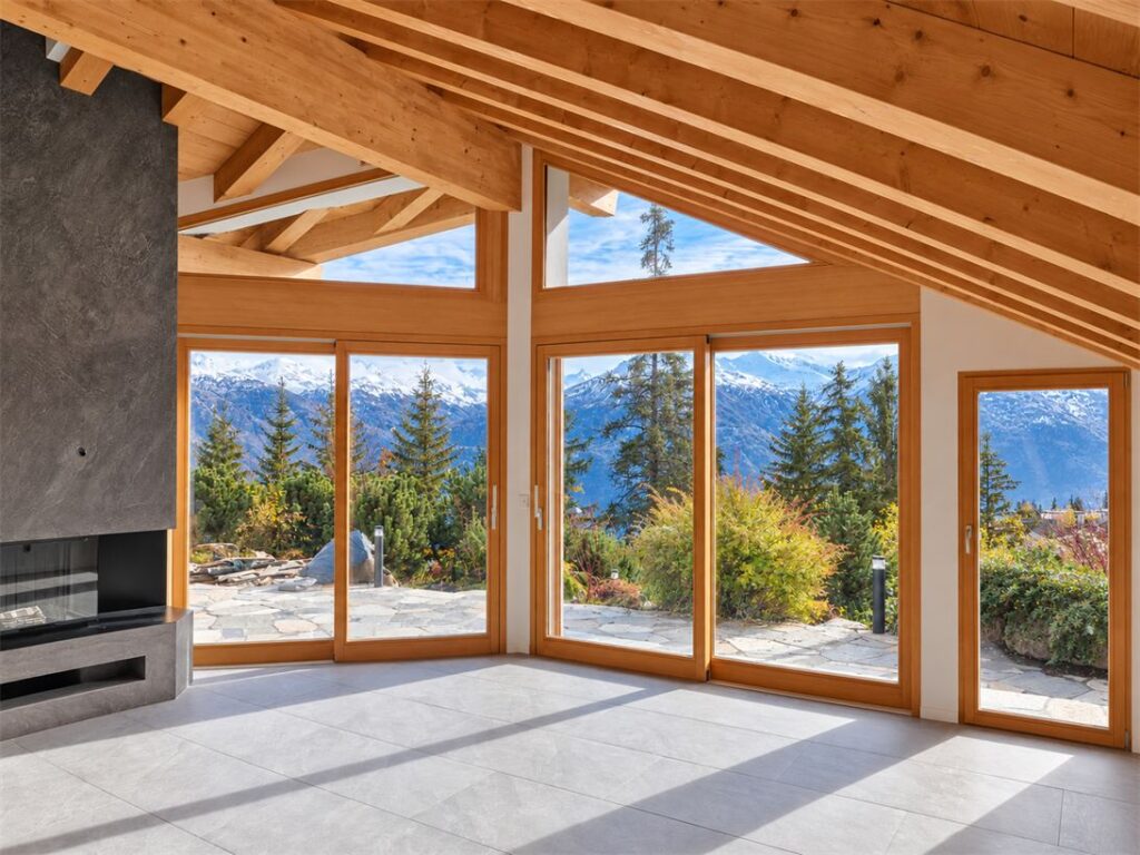 Villa mit grossen Holzfenstern mit Blick auf die Berge